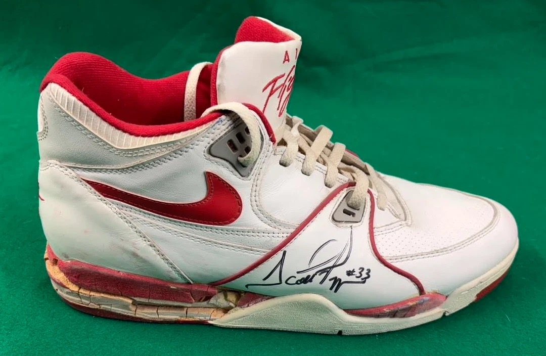 White and red Nike Air Flight sneaker signed by Scottie Pippen, #33, on a green background