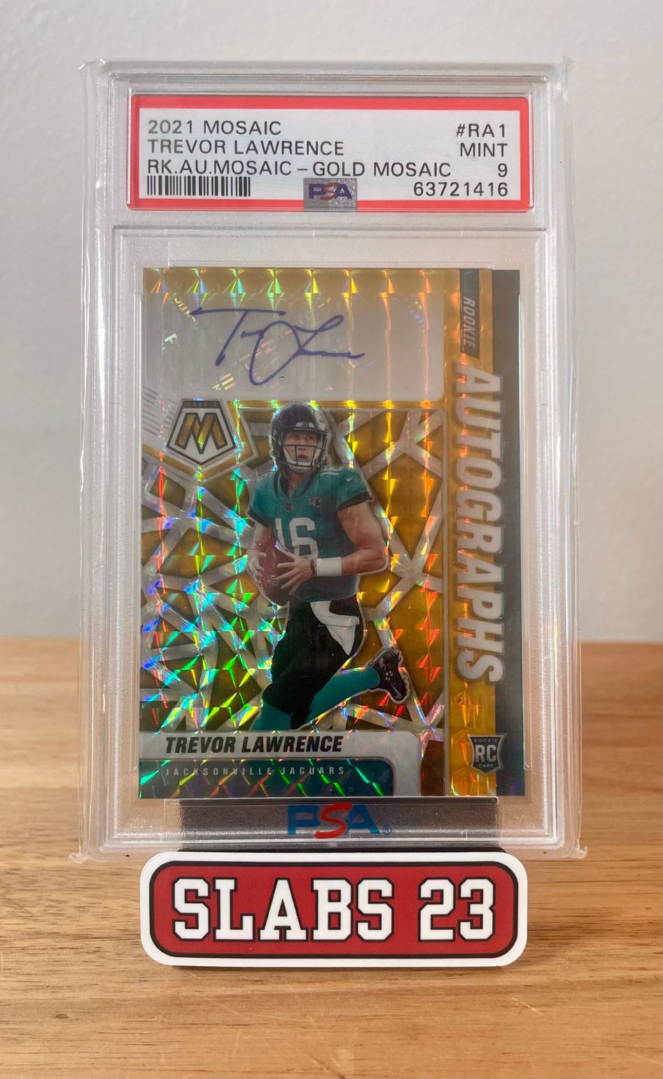 Trevor Lawrence 2021 Mosaic rookie autograph, Gold Mosaic parallel, PSA 9 Mint, on a Slabs 23 stand